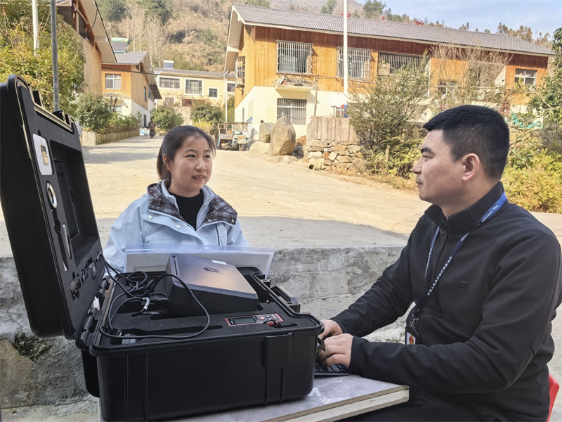 专卖证件管理人员正在现场为乡村客户办证。郝敬帆摄