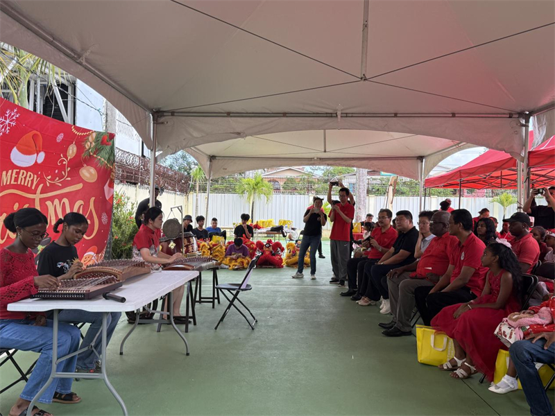 当地时间12月14日，援圭亚那中国医疗队在位于圭首都乔治敦的驻地举办“开放日”活动，图为医疗队妇产科医生李妍雨与两名圭亚那学生联袂表演古筝曲目《万疆》。 第21批援圭亚那中国医疗队供图