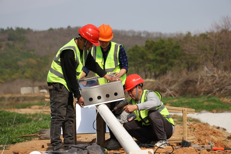 移动技术人员在田间地头安装智能监测设备。