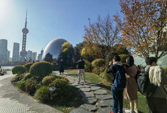 12月9日，一群外国游客在上海北外滩“小巨蛋”前排队拍照。新华社记者 陈爱平 摄