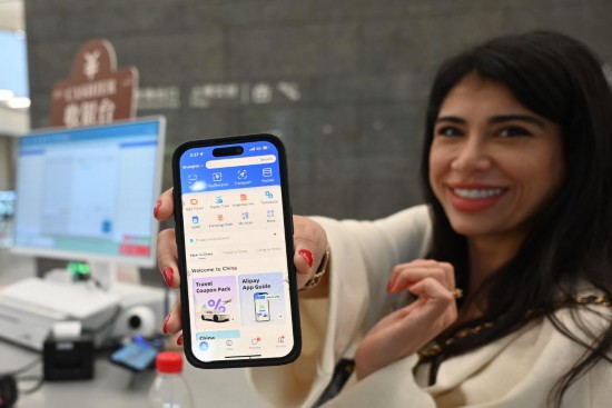 5月28日，在上海博物馆东馆文创商店，一名外国游客展示她的支付宝App。新华社记者 陈爱平 摄