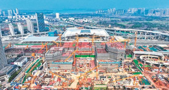 2025年3月8日，合肥西站项目工地上机器轰鸣、塔吊林立，建设者们加紧推进工程进度。
