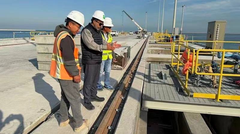 沙特阿美国王港项目总监里亚德·希班（中）在现场工作。沙特阿美供图