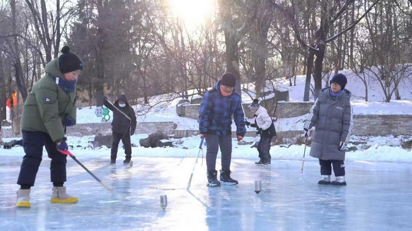 孩子们正在抽冰尜，体验冰雪运动的欢乐。哈尔滨市香坊区委宣传部供图