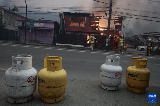 1月18日,消防员在智利比奥比奥大区彭科市救火。新华社发