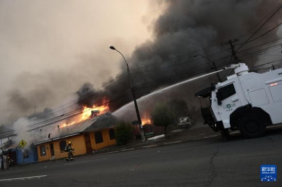 1月18日,消防员在智利比奥比奥大区彭科市救火。新华社发