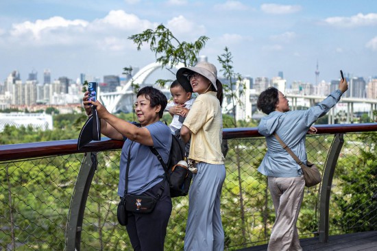 市民在世博文化公园的双子山合影留念。王初摄