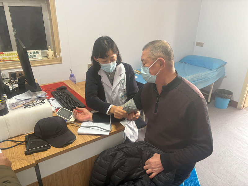 唐晓军为社区居民量血压。受访者供图