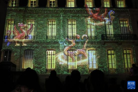 2月26日，当地民众聚集在法国巴黎中国文化中心的庭院内观赏“云冈石窟之光·巴黎回响”光雕秀。新华社记者 张百慧 摄