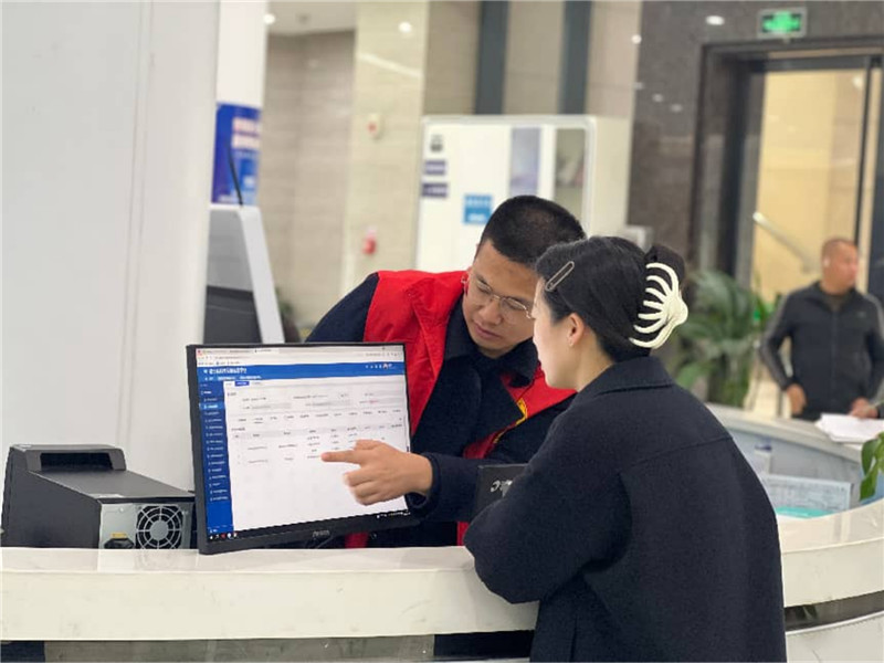 咨询台前，工作人员正为市民解答疑问、查询信息。