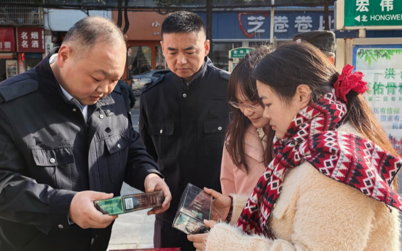 执法人员在宣传点为群众讲解烟草制品辨假识假技巧。