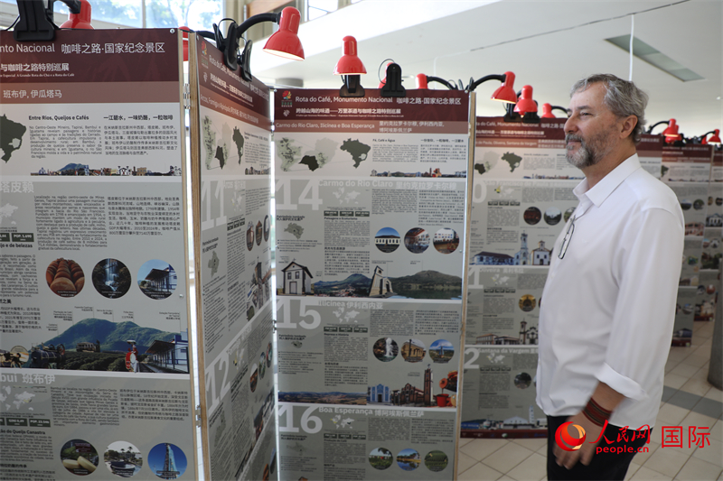 图为一位来自巴西米纳斯吉拉斯州的文化工作者正仔细端详展板上的历史影像， 感受中巴文明对话的独特魅力。人民网记者 陈一鸣摄