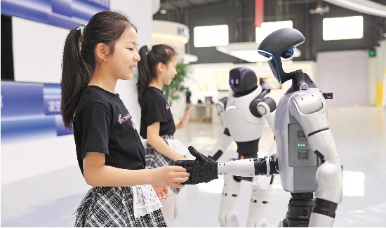 6月19日，东营融瓴机器人联盟科技探索基地，孩子们与机器人握手互动，感受智能科技魅力。(周广学 报道)