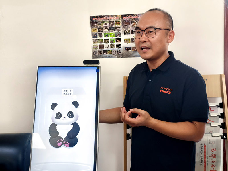 在西岔河镇银厂沟村,已在佛坪扎根五年的阿里巴巴乡村振兴特派员高泉向调研团队介绍AI一体机。人民网记者 孙博洋摄
