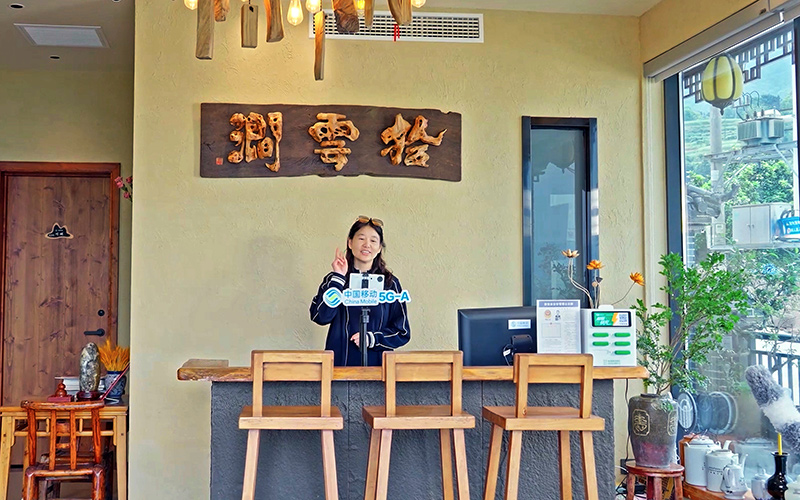 依托中国移动高速网络，田恒兰在自家民宿内开直播。