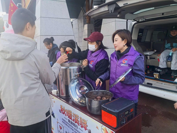 在溪水公园,巾帼志愿者设立服务台,为游客免费发放茶叶蛋、玉米等。